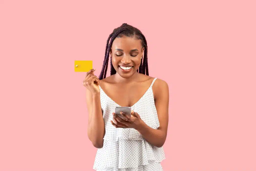 Young lady holding her mobile phone and visa card